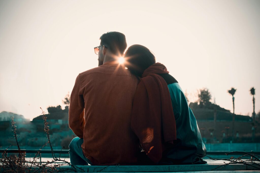 two adults sitting together in warm sunlight symbolising attachment styles in adults and how early patterns shape relationships